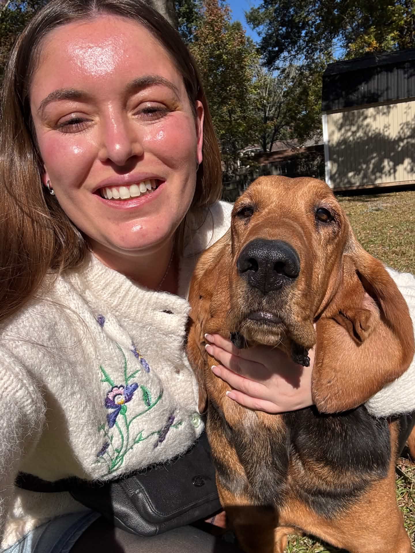 Alexis smiling with a bloodhound